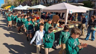 Niños pasean por la Rambla Nova con las paradas de fondo. Foto: Àngel Ullate