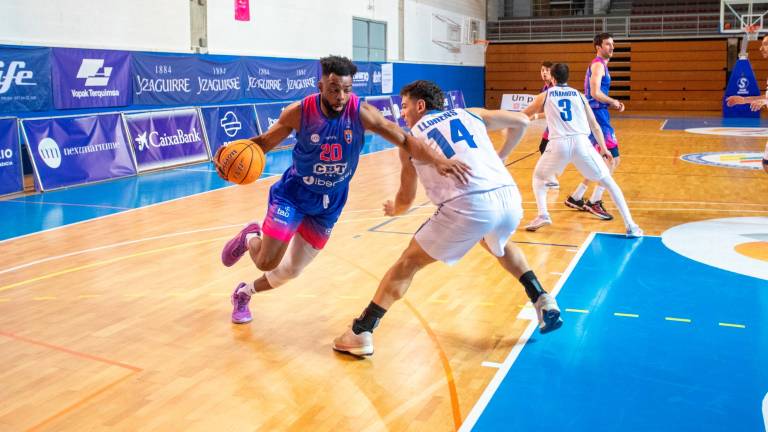El último fichaje del CBT, Tope Arikawe, bota el balón frente a su excompañero en el Prat Ferran Llorens. Foto: Marc Bosch